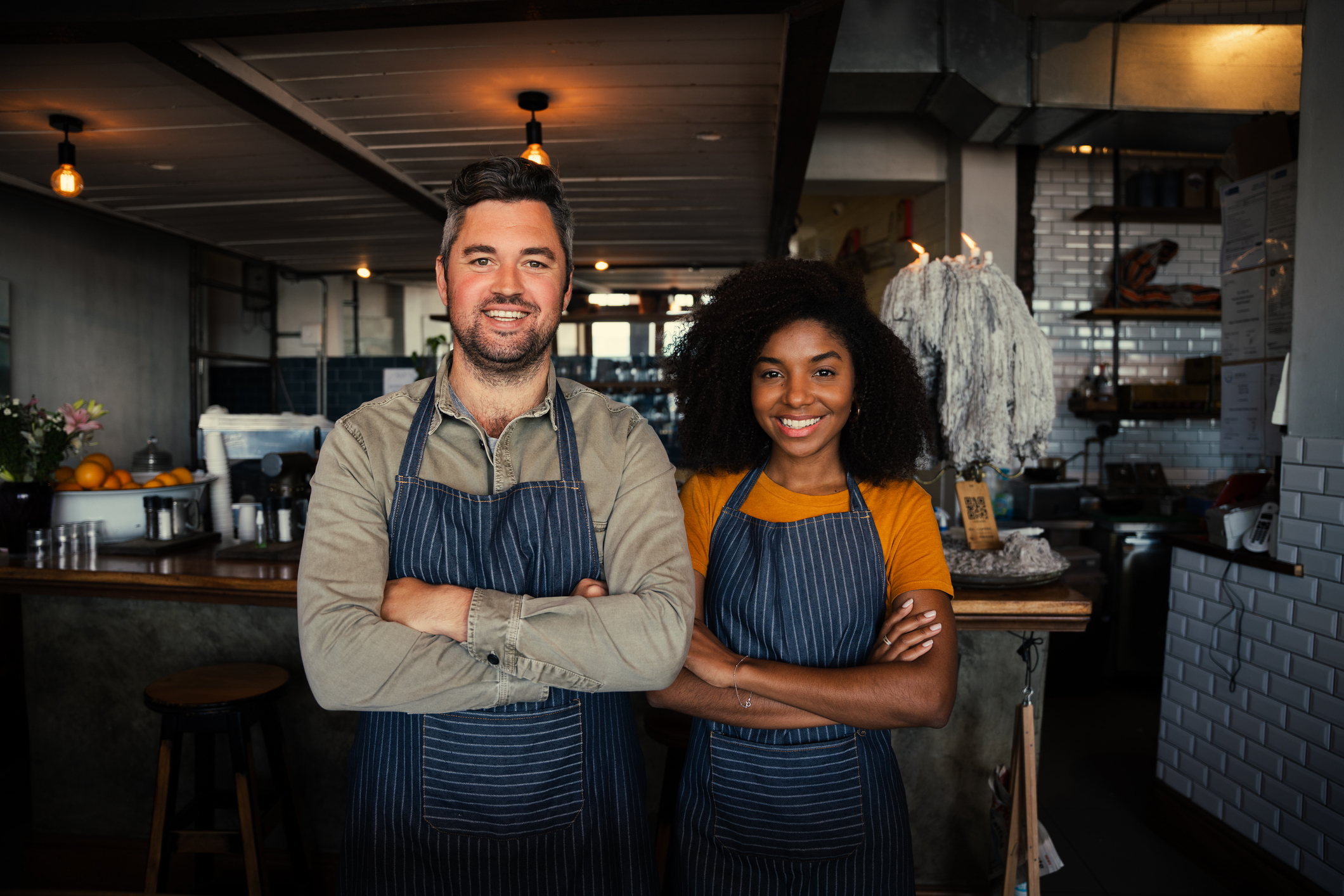 Two restaurant owners standing confidently in their restaurant